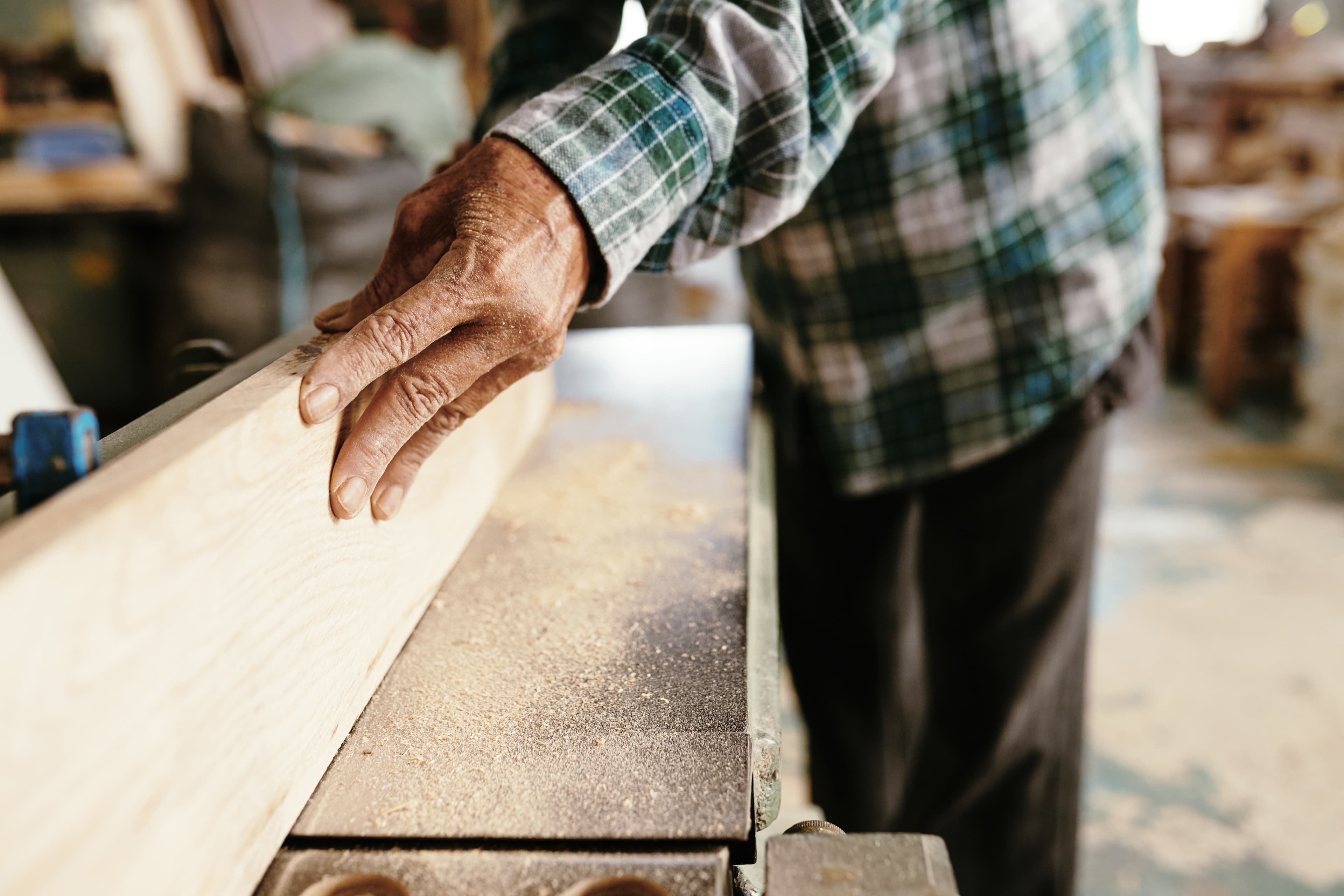 Hands working a piece of timber.